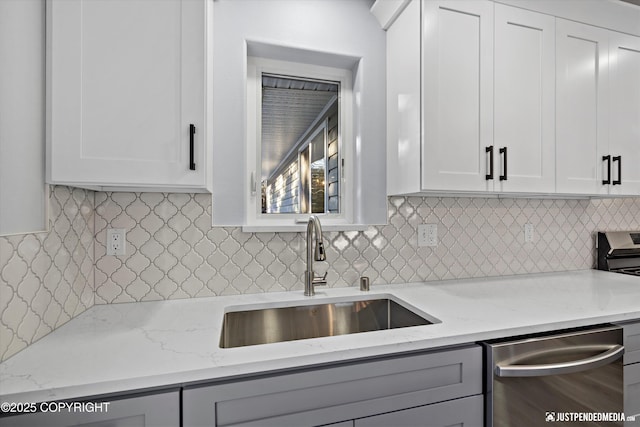 kitchen with light stone counters, dishwasher, and a sink