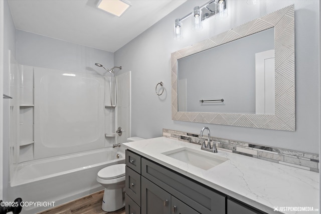 bathroom featuring vanity, toilet, wood finished floors, and  shower combination