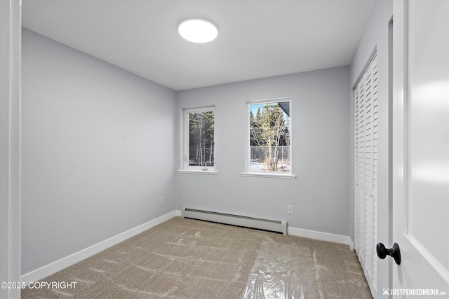 unfurnished bedroom featuring baseboard heating, baseboards, and carpet