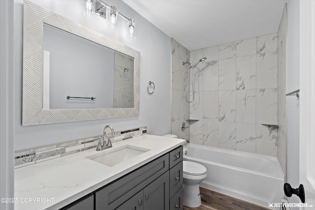 bathroom with vanity, wood finished floors, toilet, and bathtub / shower combination