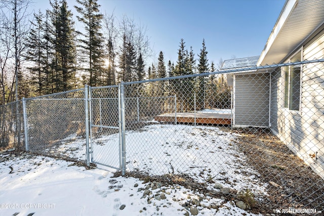 yard layered in snow with a gate and fence