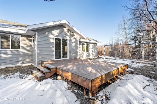 snow covered deck featuring fence