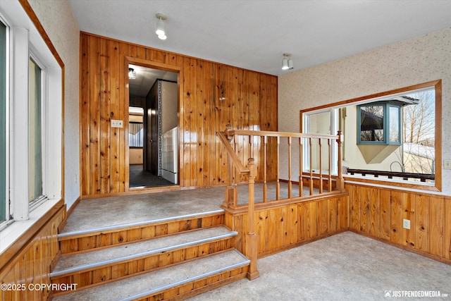 stairway featuring carpet floors and wood walls