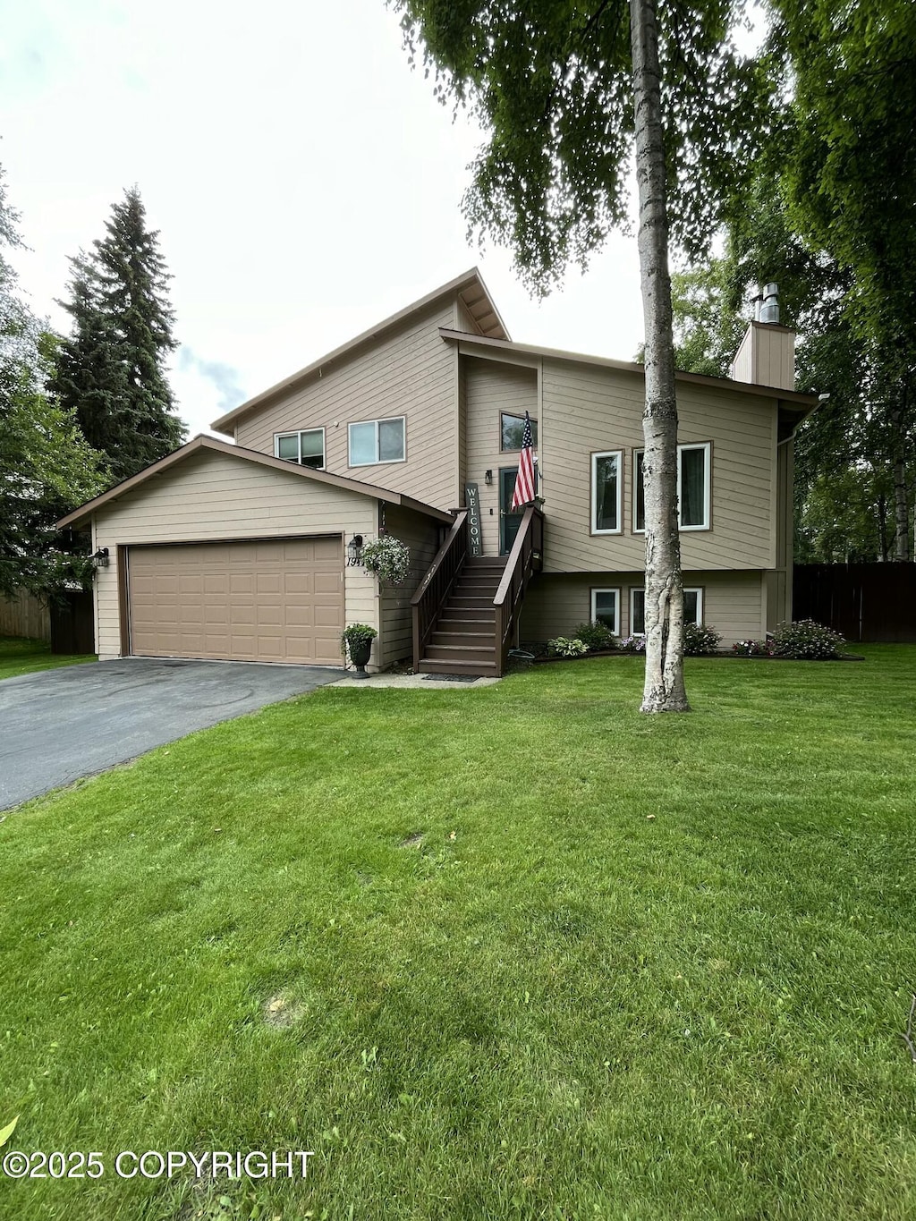 view of front of house with a garage, driveway, a chimney, and a front yard