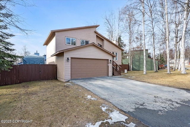 exterior space featuring aphalt driveway, an attached garage, and fence