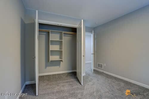 unfurnished bedroom with a closet, visible vents, baseboards, and carpet floors