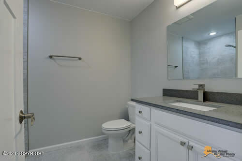 bathroom featuring baseboards, toilet, and vanity