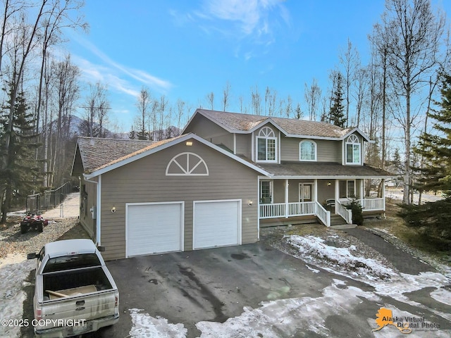 view of front of home featuring aphalt driveway, a porch, and a garage