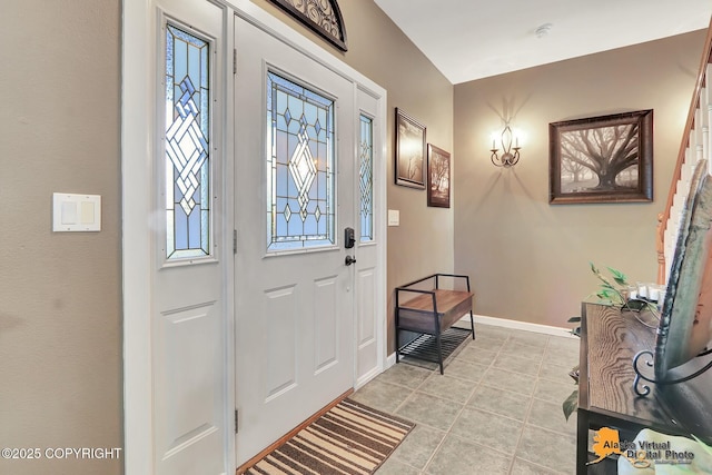 foyer entrance with light tile patterned floors and baseboards