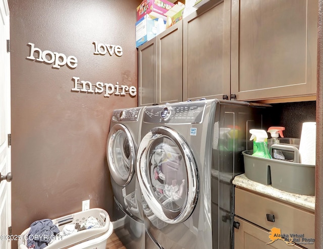 laundry room featuring cabinet space, a textured wall, and separate washer and dryer