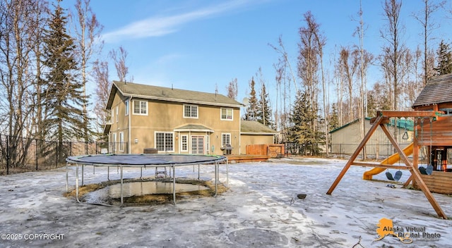 back of house with a playground, a trampoline, fence, and a wooden deck