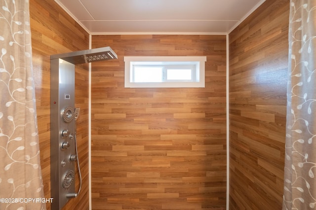 full bathroom featuring a shower with shower curtain, wood walls, and ornamental molding