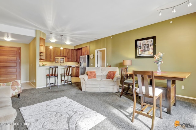 living room with rail lighting, baseboards, and light carpet