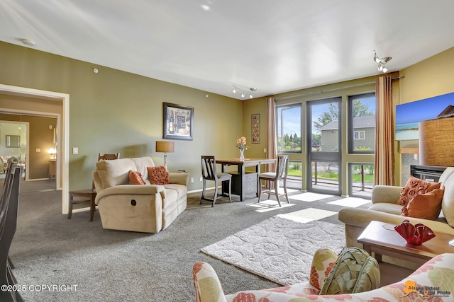 carpeted living room featuring baseboards and a fireplace