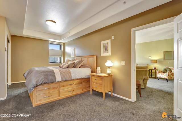 carpeted bedroom featuring a tray ceiling and baseboards