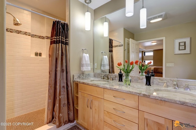 ensuite bathroom featuring double vanity, visible vents, ensuite bathroom, and a sink