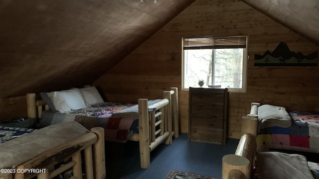 bedroom featuring lofted ceiling and wood walls