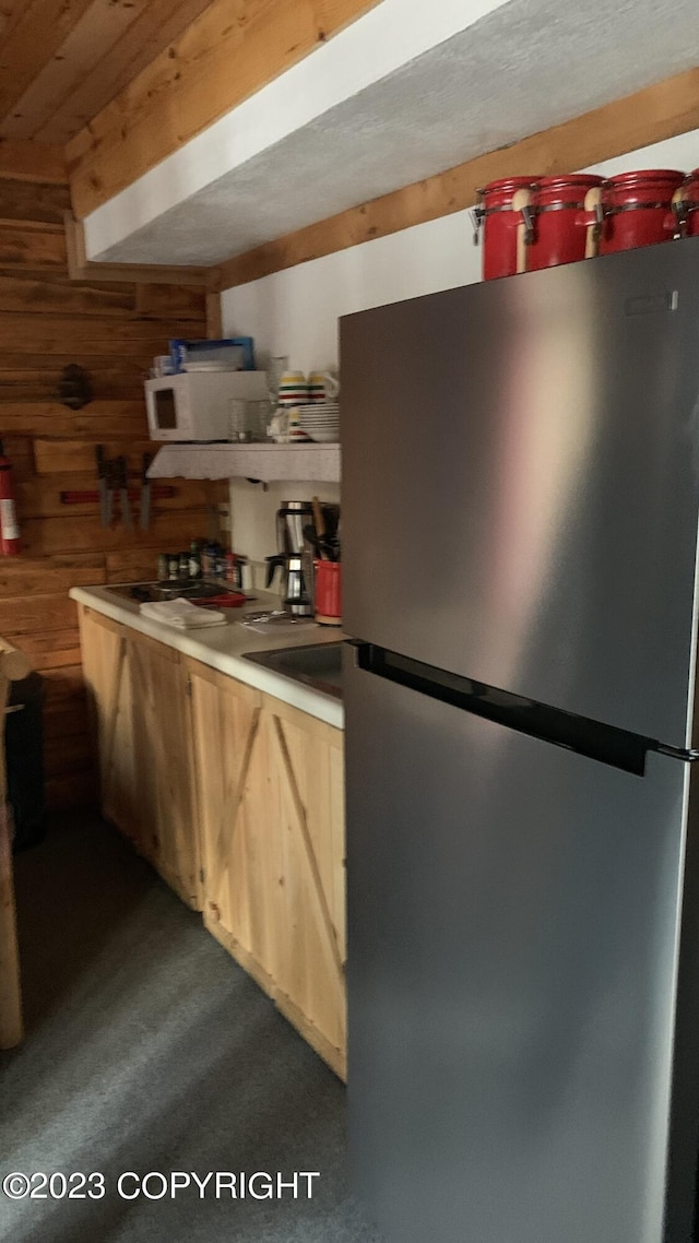 kitchen with wooden walls, wooden ceiling, and freestanding refrigerator