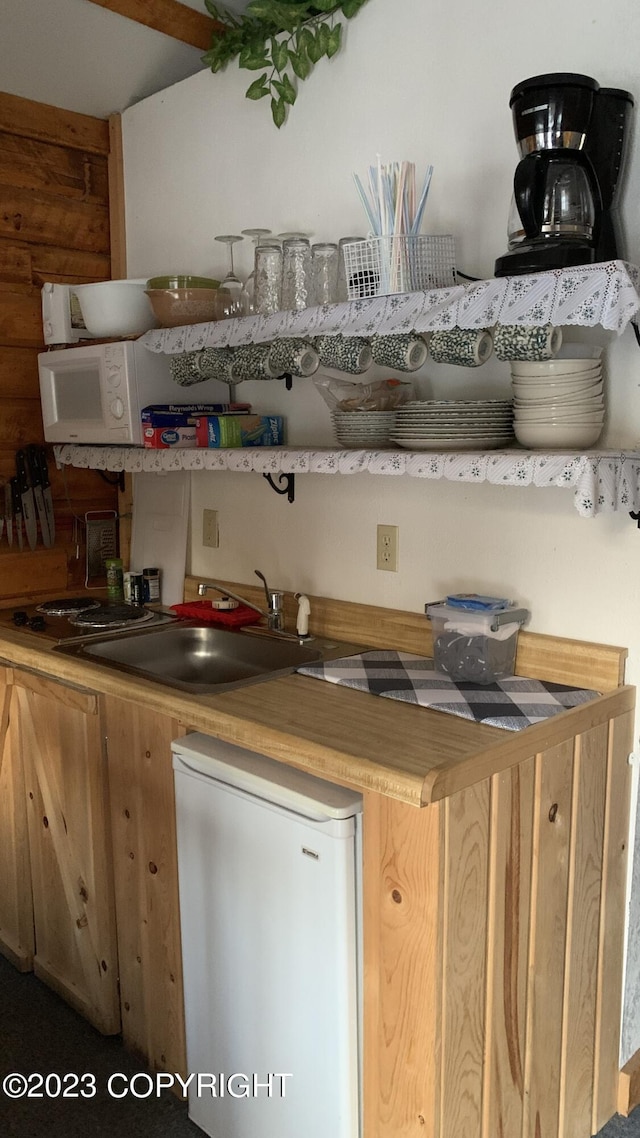 bar featuring a sink and white refrigerator