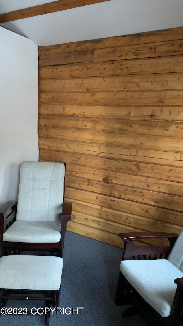 living area featuring carpet floors and wooden walls