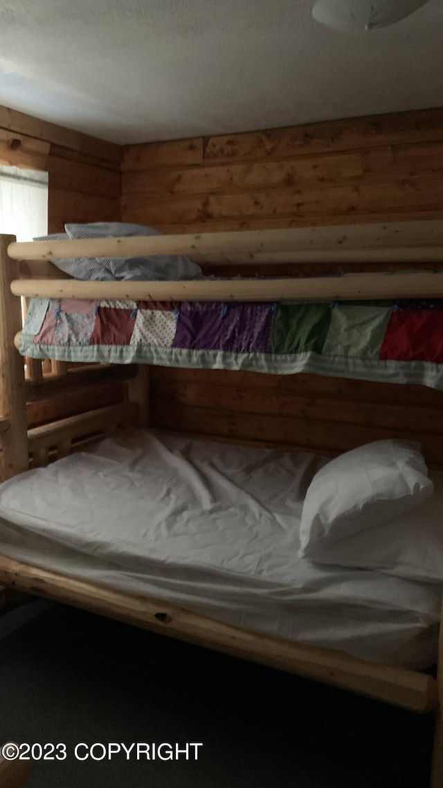 bedroom featuring wood walls