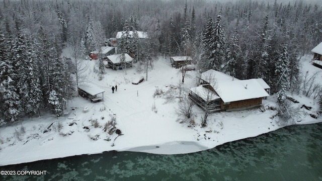 snowy aerial view with a wooded view