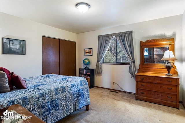 bedroom featuring a closet, visible vents, light colored carpet, and baseboards