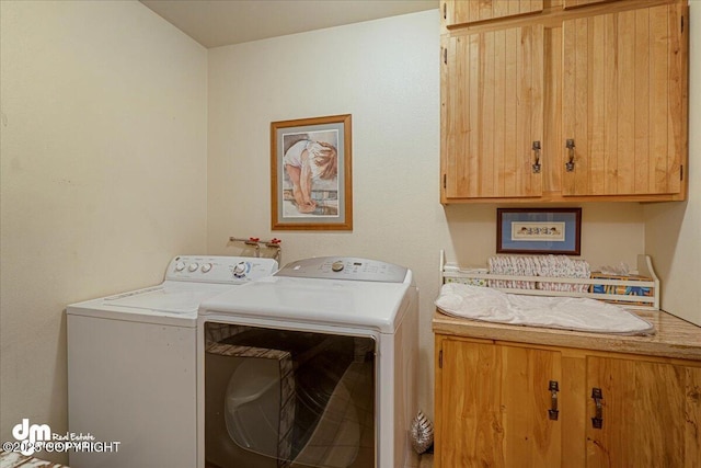 clothes washing area with cabinet space and washing machine and dryer