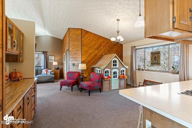 playroom featuring a textured ceiling, wooden walls, carpet, lofted ceiling, and a chandelier