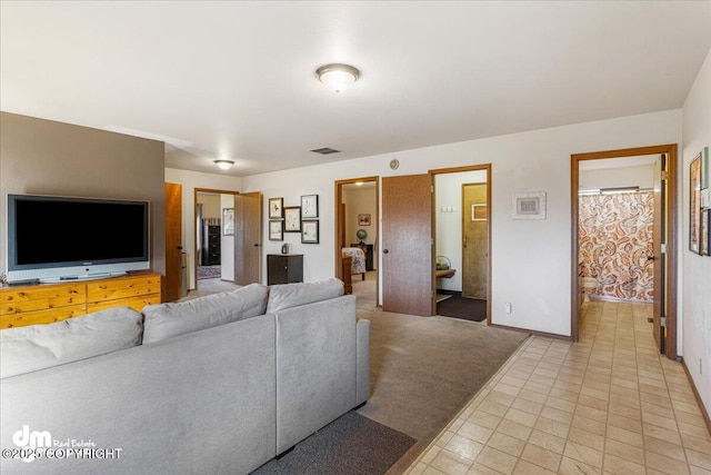 living room with visible vents, light carpet, and baseboards