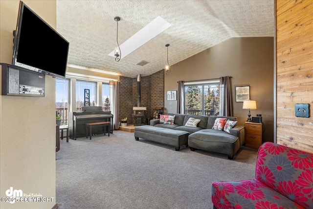 carpeted living room featuring visible vents, high vaulted ceiling, a wood stove, a skylight, and a textured ceiling