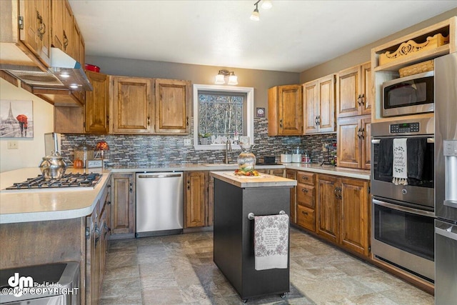 kitchen with tasteful backsplash, a center island, stainless steel appliances, and light countertops