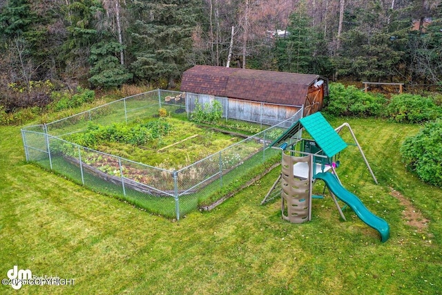 view of play area featuring an outdoor structure, a garden, a lawn, and fence