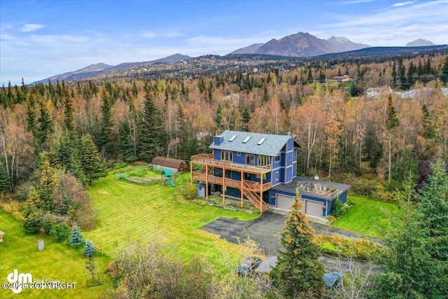 drone / aerial view with a mountain view and a view of trees