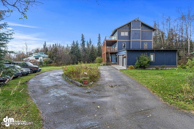 view of front of home featuring a garage, a front lawn, driveway, and stairway