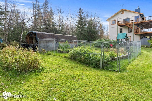 view of yard with an outbuilding, a vegetable garden, and fence