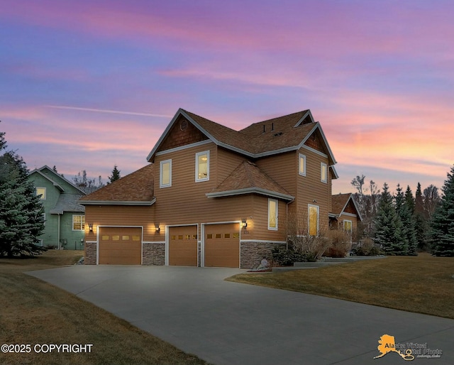 view of front of house featuring a front lawn, concrete driveway, stone siding, and an attached garage