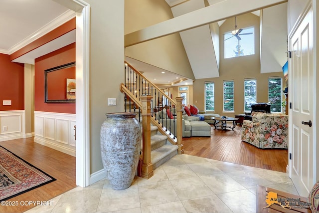 interior space with crown molding, stairway, a decorative wall, and wood finished floors