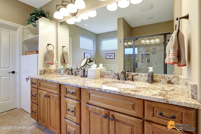 bathroom with double vanity, tile patterned floors, a stall shower, and a sink