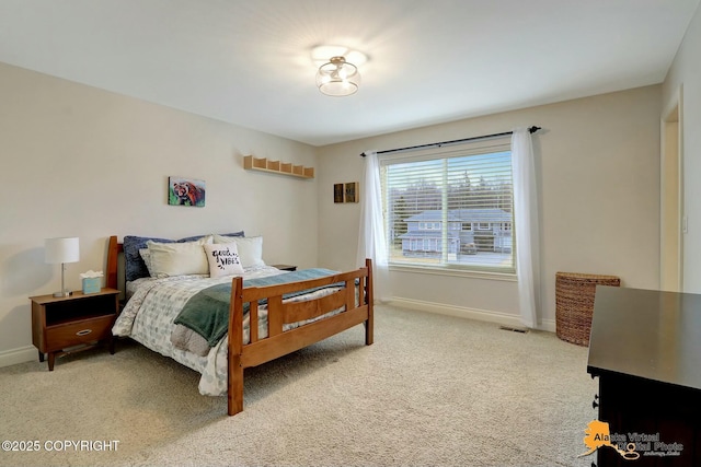 bedroom with baseboards, light carpet, and visible vents