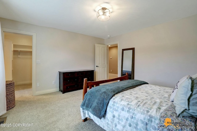 bedroom with carpet flooring, a walk in closet, and baseboards