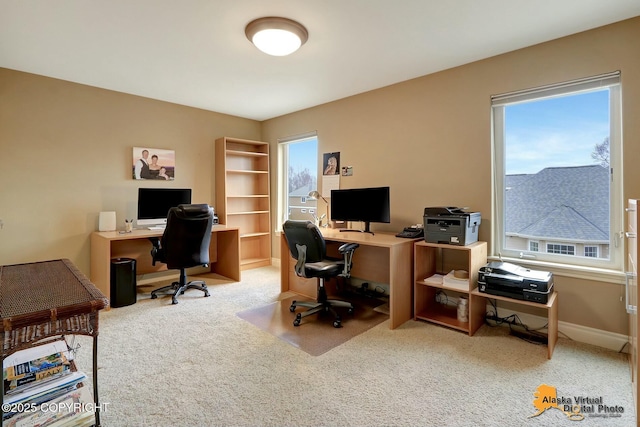 carpeted office space featuring plenty of natural light and baseboards