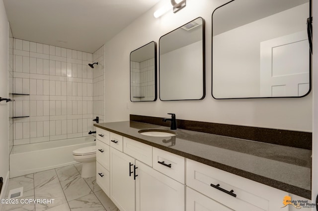 full bathroom with washtub / shower combination, toilet, marble finish floor, and vanity