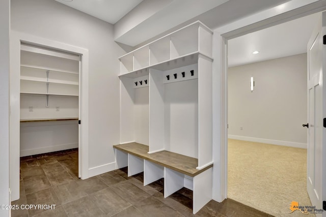 mudroom featuring baseboards and carpet