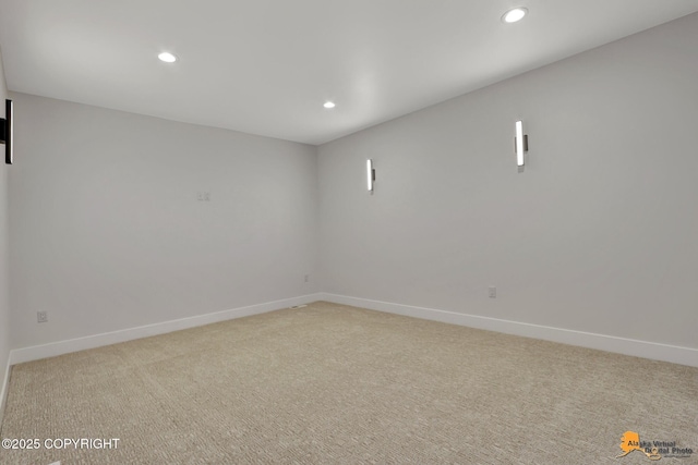 spare room with recessed lighting, light colored carpet, and baseboards