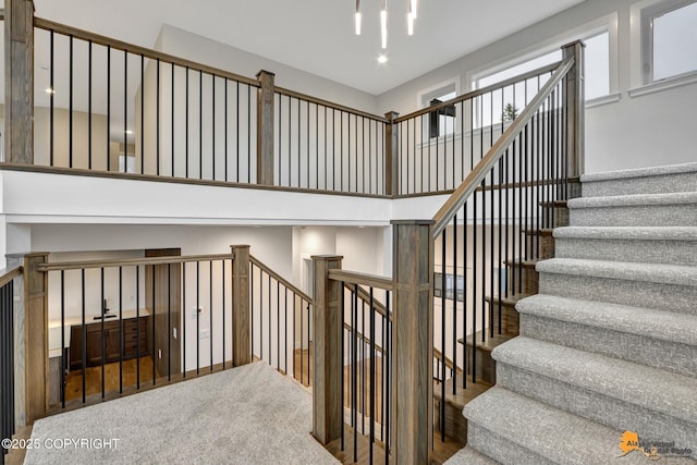 stairs featuring carpet flooring and a chandelier