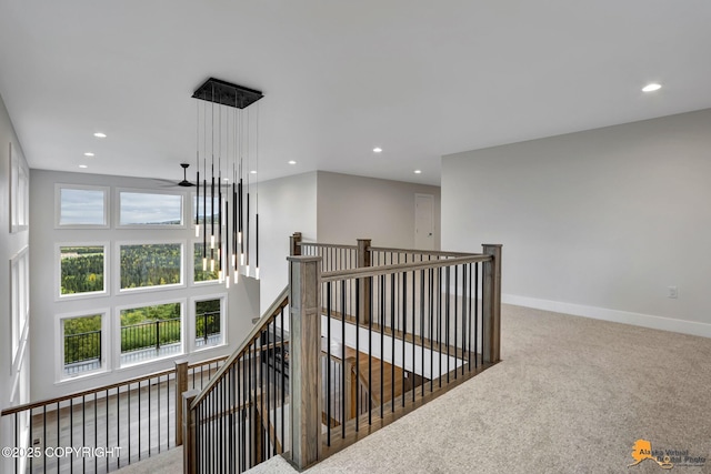 hallway featuring baseboards, a high ceiling, recessed lighting, carpet flooring, and an upstairs landing