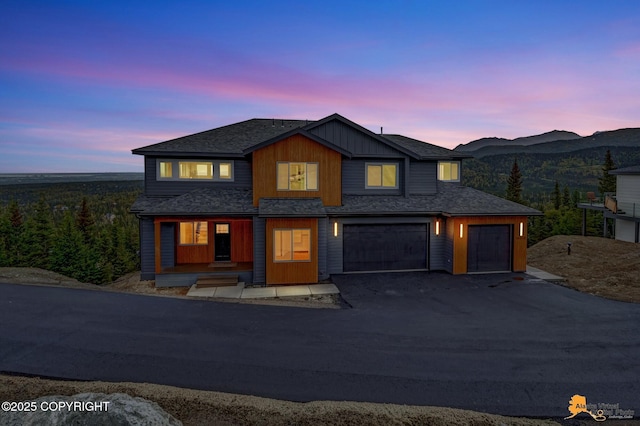 view of front facade with aphalt driveway, a mountain view, a garage, and roof with shingles