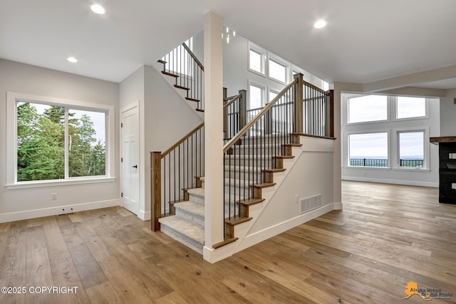 stairs featuring visible vents, baseboards, and wood-type flooring