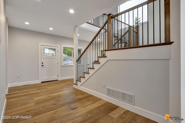 entryway with stairway, baseboards, visible vents, recessed lighting, and wood-type flooring